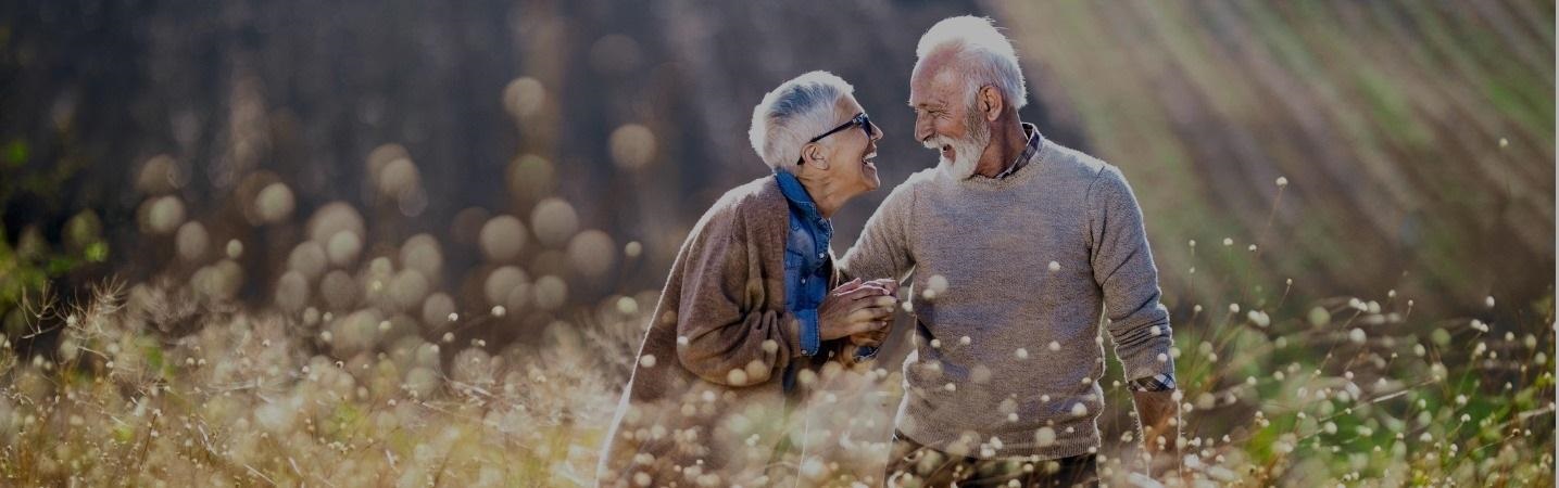 Cheerful senior couple talking on a hill