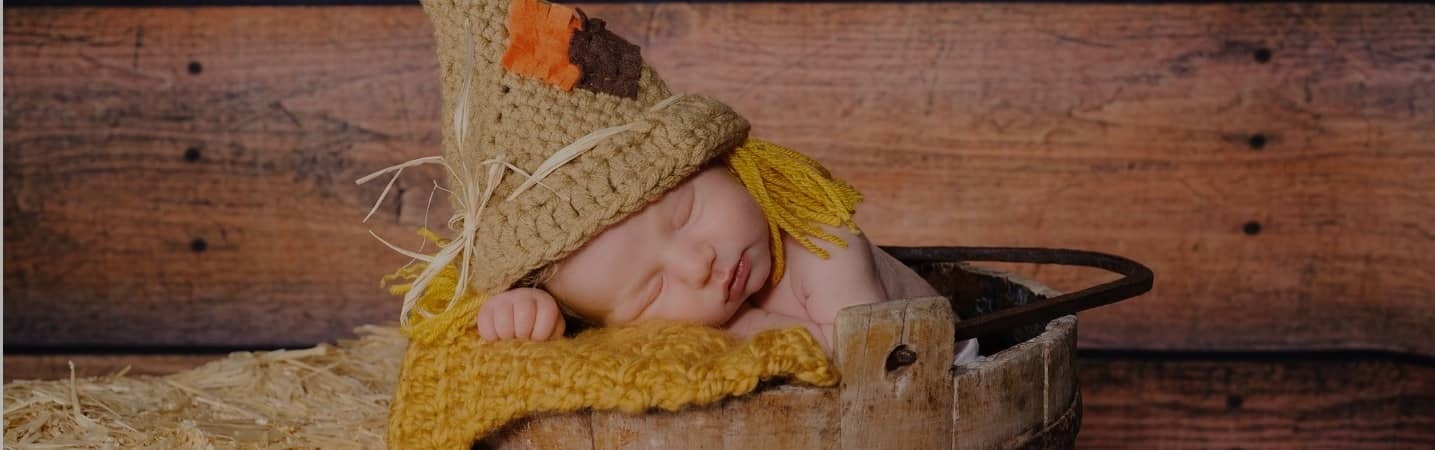 Newborn baby wearing a scarecrow outfit