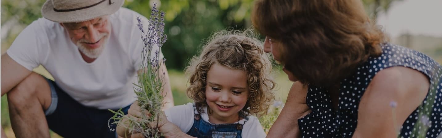 Senior grandparents and granddaughter gardening in the backyard
