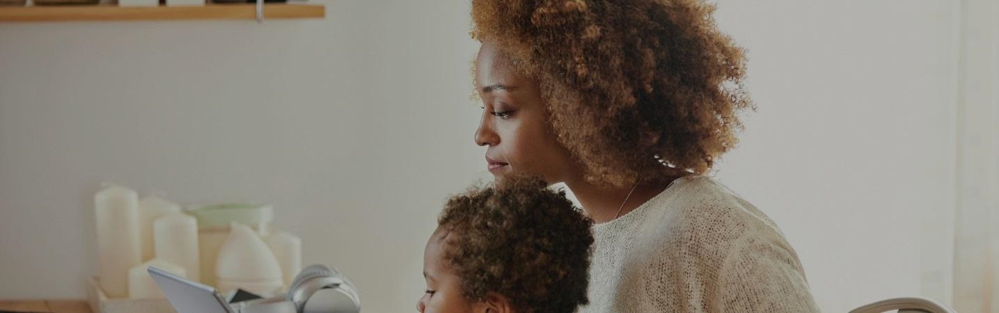 Mother with son working at home on digital tablet