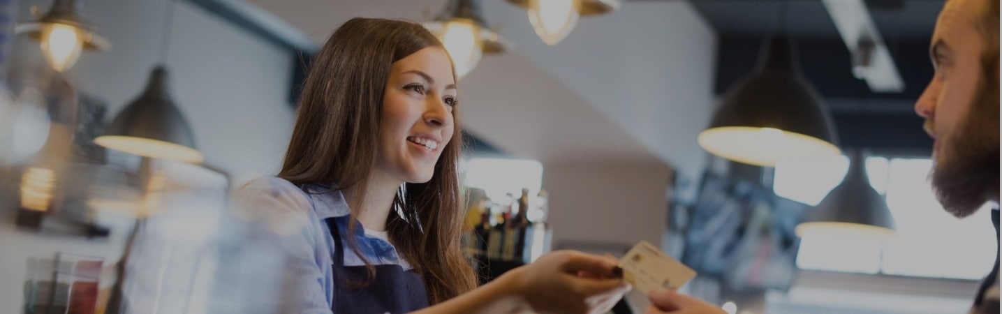 business woman handing debit card to customer