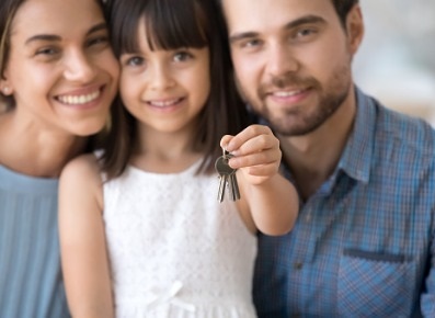 Smiling young family with key to new home