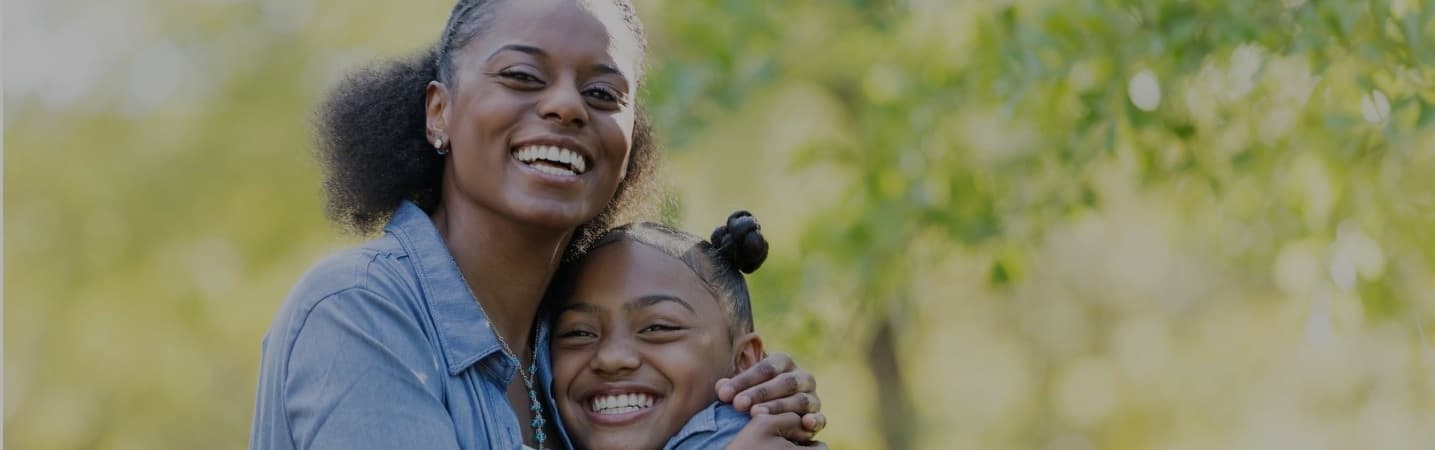 African american mother and daughter hugging outdoors