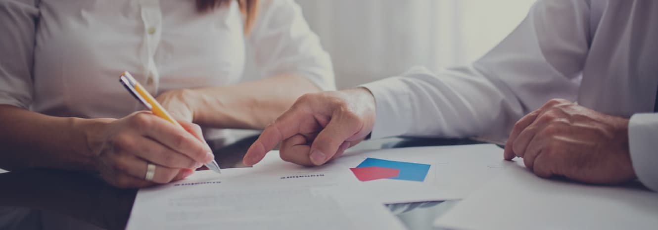 Man showing woman where to sign on a form