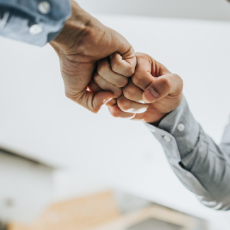 Two businessmen fist bumping.