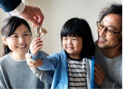 Asian family buy a new house, young girl receiving keys.