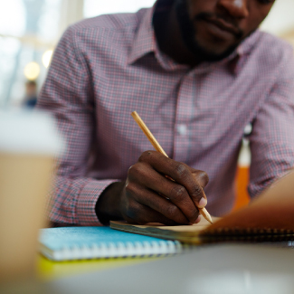 African american man writing notes.