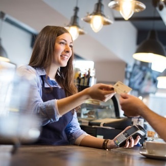 Young business woman accepting debit card from customer