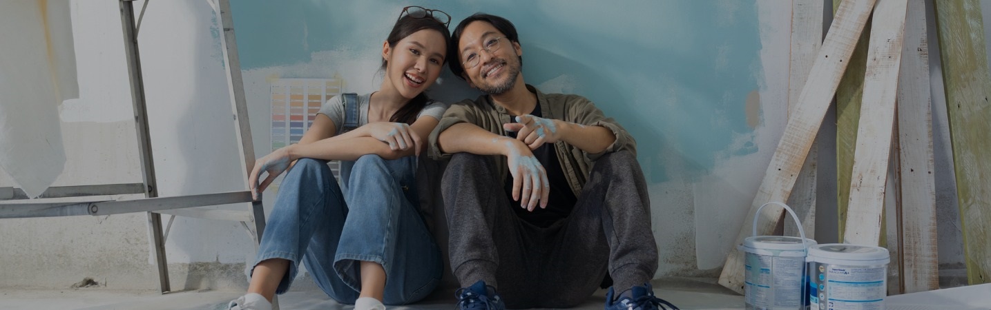 Young couple taking a break from painting a room