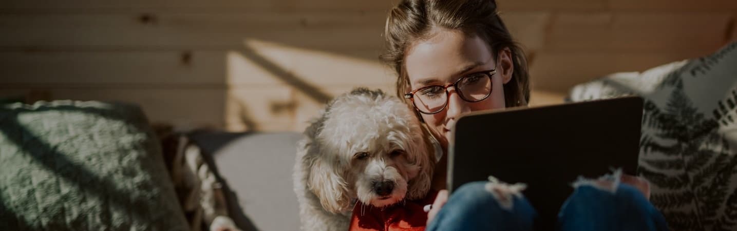 Young woman with her dog working on tablet