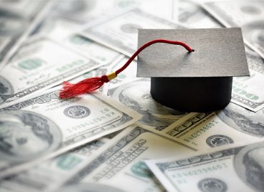 Graduation cap on pile of money