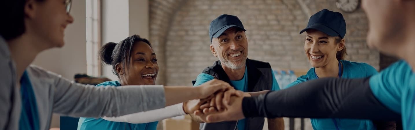 volunteers gathering hands in unity after meeting