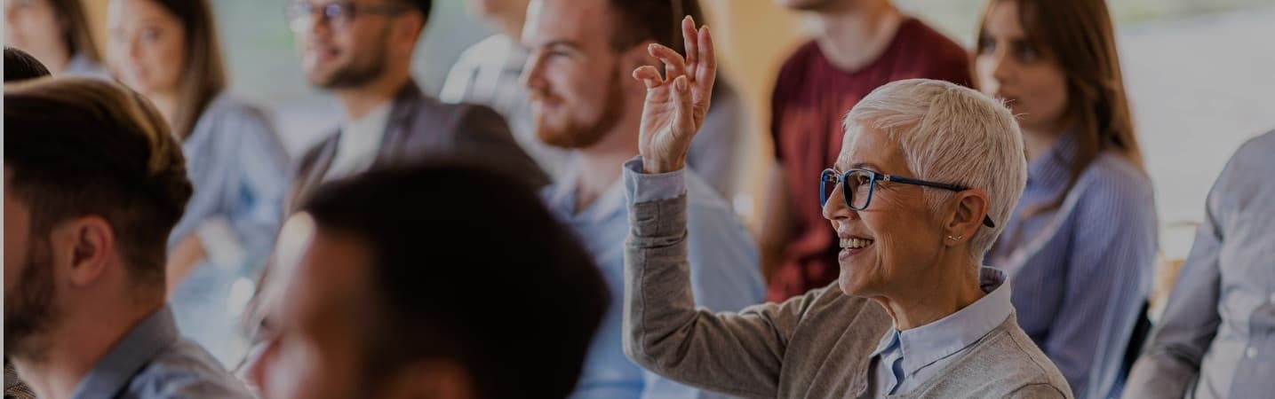 Woman raising her hand at a seminar