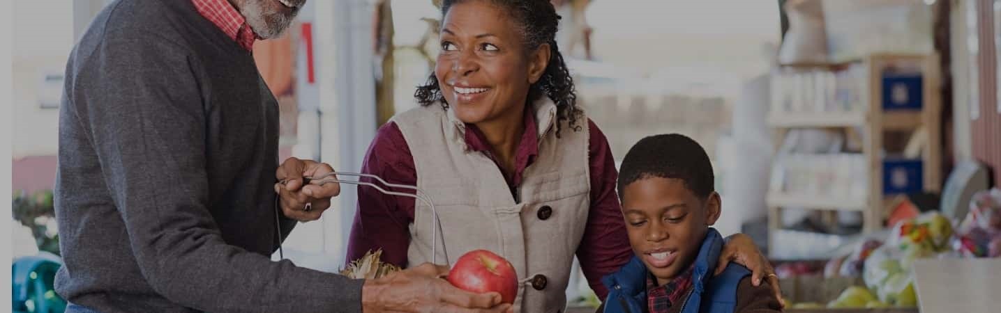 Grandparents and grandson selecting apples