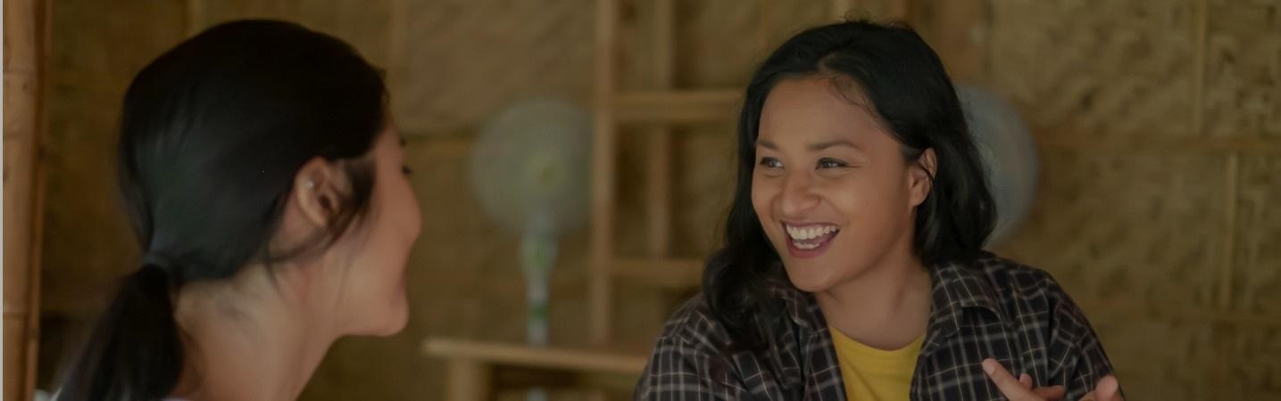 Ethnic volunteers chatting in a sustainable bamboo building