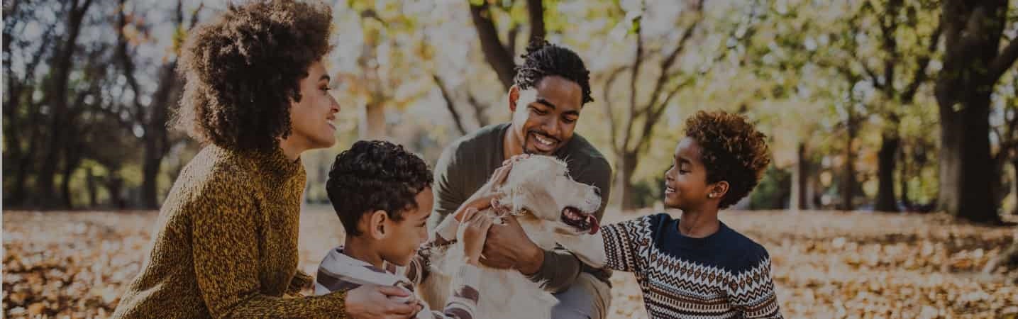 African American family enjoying their dog in the park