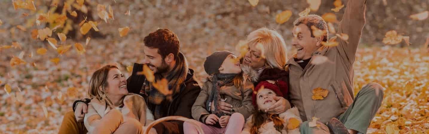 Playful multigeneration family among autumn leaves on a picnic
