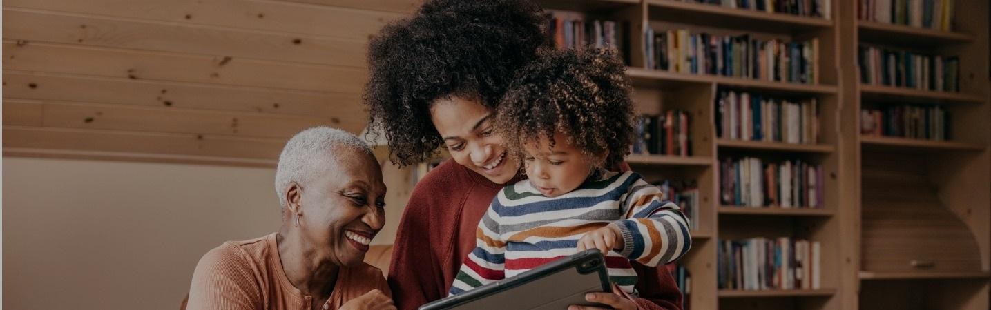 three generations - mother grandmother and granddaughter  looking at a laptop