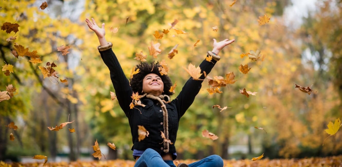 Joyous teen playing in the leaves