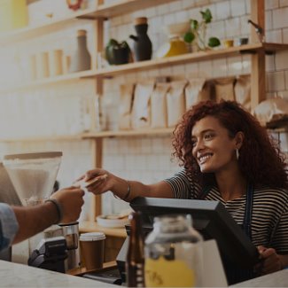 Young woman business owner handing credit card back to customer