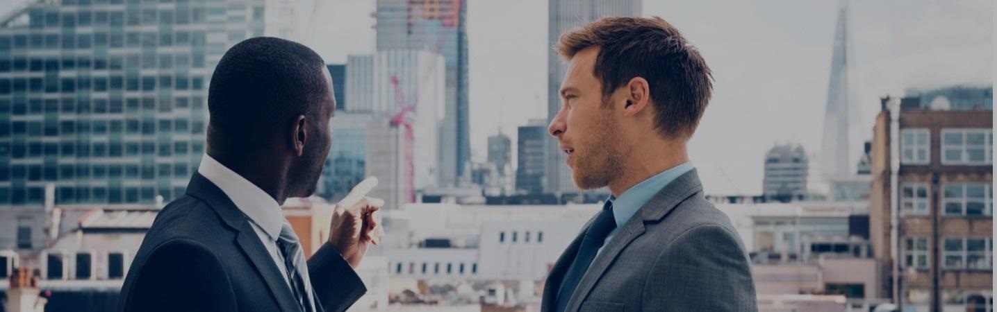 businessmen having a discussion looking over the cityscape