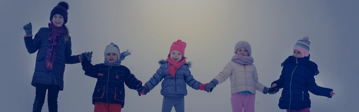 group of children holding hands in the snow