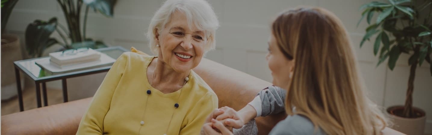 Elderly mother talking with her daughter in the living room