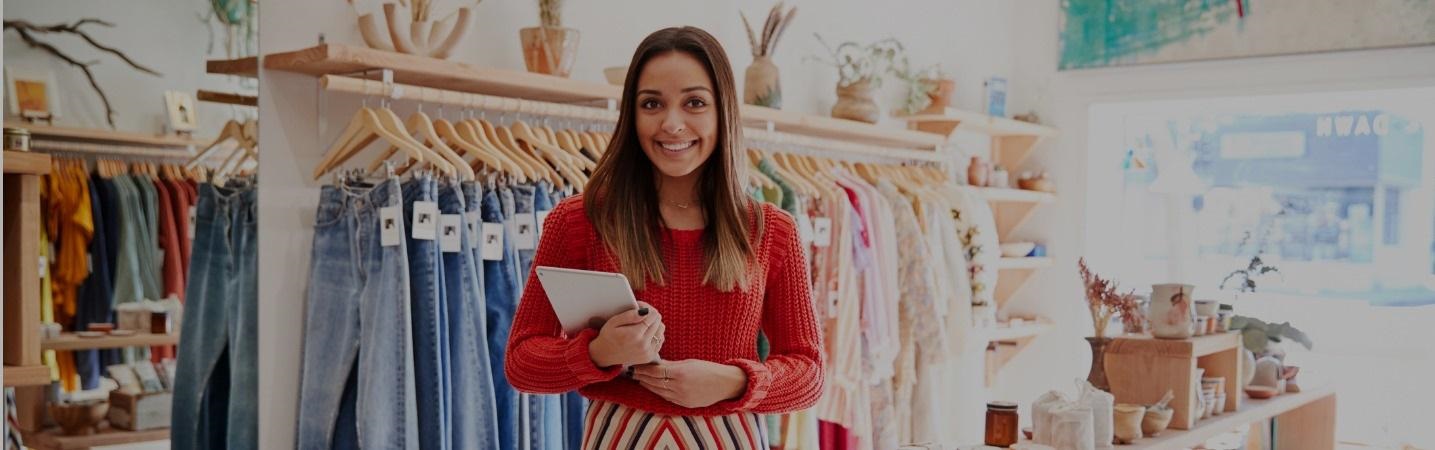 Smiling female owner of independent clothing and gift store