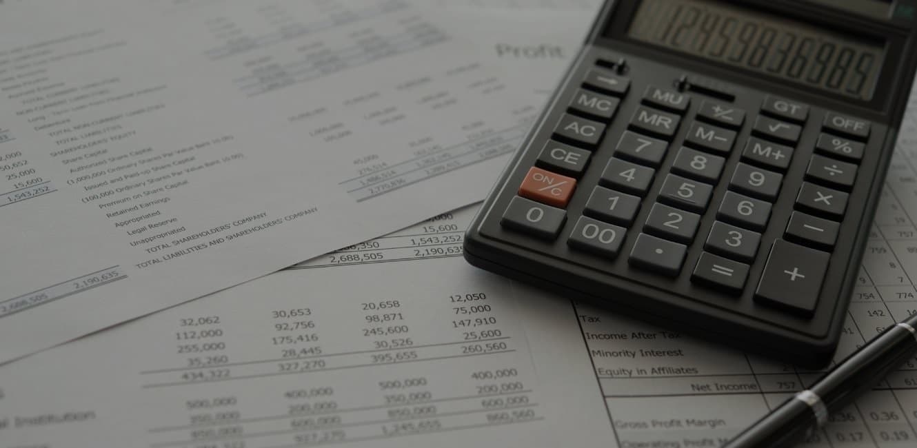 financial statement documents with calculator and pen